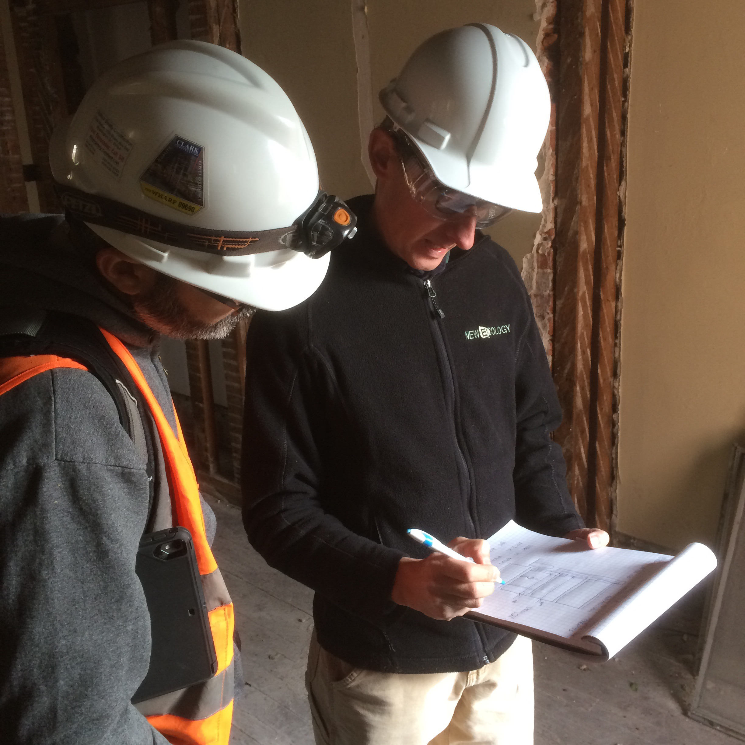 2 men in hard hats reviewing notes