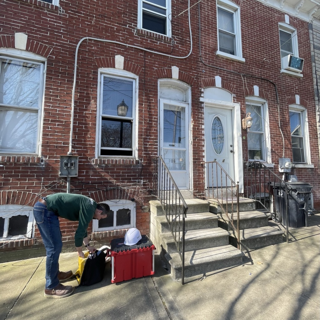 man unpacking tools outside of rowhomes in Wilmington, DE